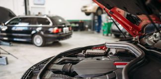 Car with opened hood in automobile service