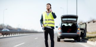 Man calling road assistance on the highway