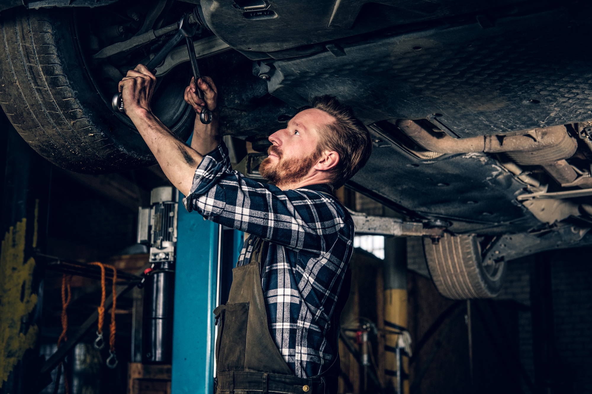 Mechanic balancing car's wheel in a workshop.